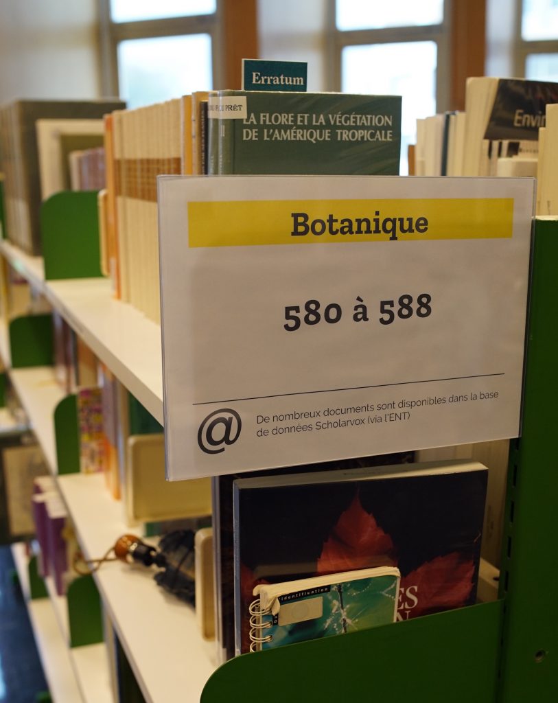Une étagère de bilbiothèque avec des livres de botanique.