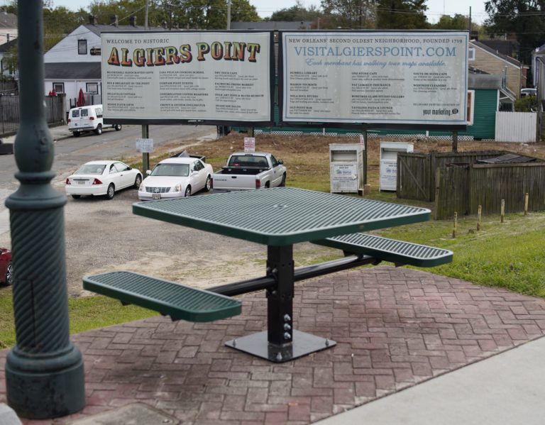 Une table à pique-nique avec un panneau touristique en arrière-plan.