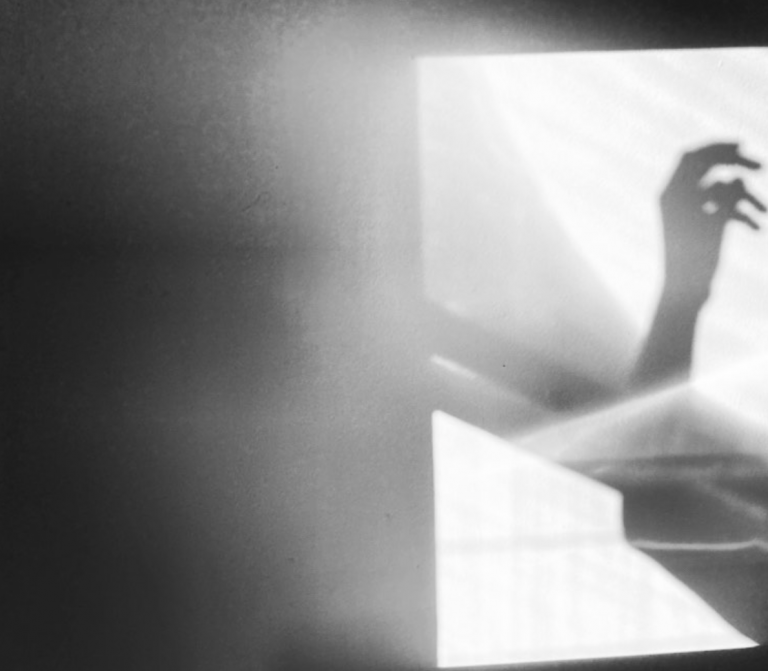 Photographie de l'ombre d'une main dans le devant la lumière du soleil.