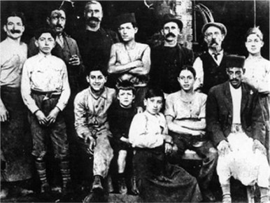 Albert Camus enfant et son oncle Étienne Sintès (debout, derrière lui) dans l’atelier de la tonnellerie Liuzzi et Spinelli à Belcourt